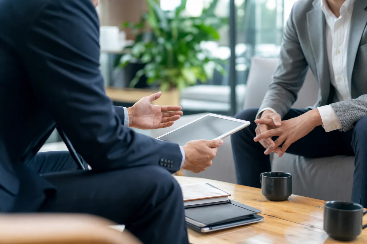 Consultant indépendant en réunion avec un client, discussion autour d&rsquo;un devis sur tablette